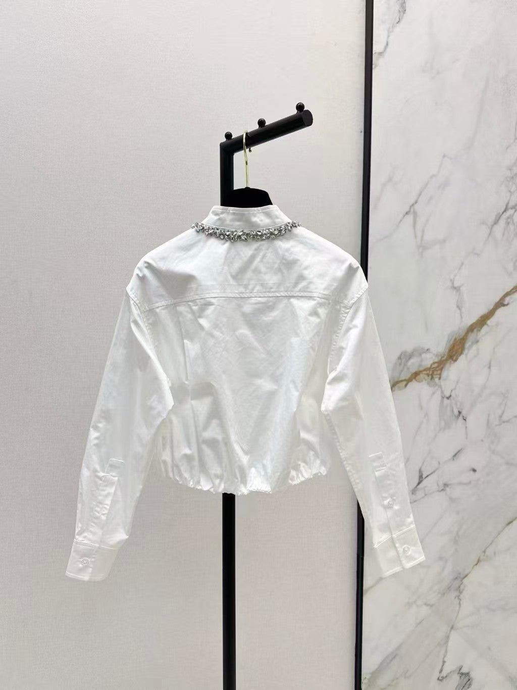 The new heavyweight is a short white shirt decorated with rhinestones